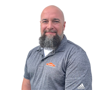 Man with dark beard in gray SERVPRO shirt against white backdrop
